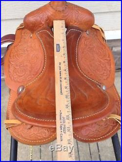 Lightly used 12 US made tooled light oil leather pony saddle withsafety stirrups